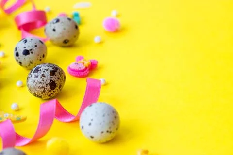 Easter eggs background - quail eggs and decoration on yellow background 库存照片