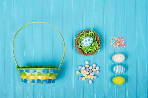Easter eggs, basket, and candy on a blue background Stock Photos