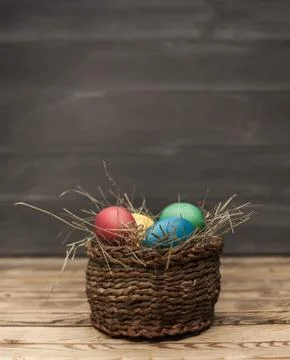 Easter eggs in a basket with hay Stock Photos