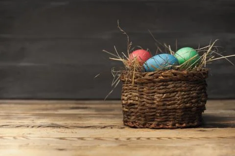 Easter eggs in a basket with hay Stock Photos