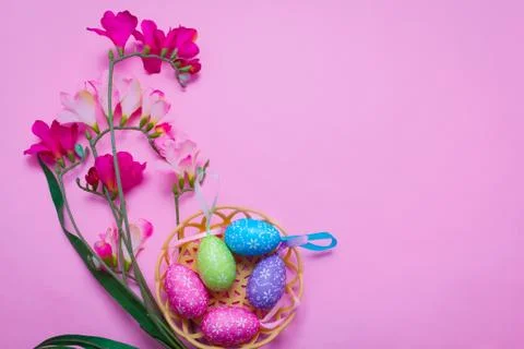 Easter eggs in a basket on a pink background 库存照片