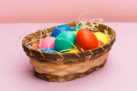 Easter eggs in basket  on pink background 库存照片