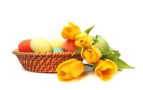 Easter eggs in basket with tulips Stock Photos