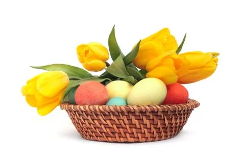 Easter eggs in basket with tulips Stock Photos