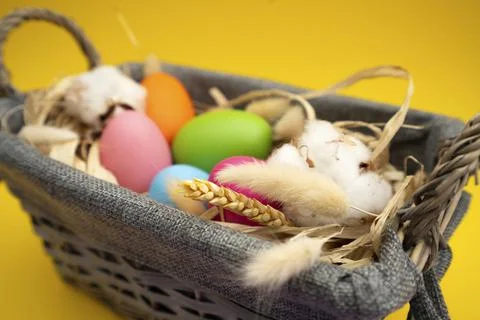 Easter Eggs in basket on yellow background Stock Photos