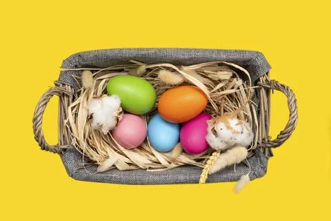 Easter Eggs in basket on yellow background Stock Photos
