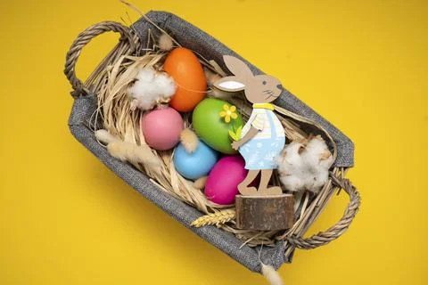 Easter Eggs in basket on yellow background Stock Photos