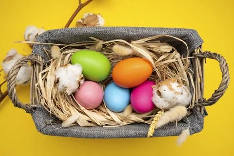Easter Eggs in basket on yellow background Stock Photos