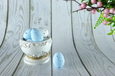 Easter eggs in a beautiful white stand on a white wooden background. Stock Photos