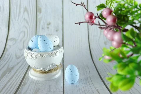 Easter eggs in a beautiful white stand on a white wooden background. Stock Photos