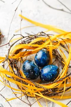 Easter Eggs in bird Nest. Quail easter eggs with feathers in nest on white .. Stock Photos