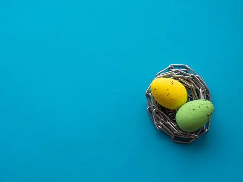 Easter eggs on blue background with metal chain Stock Photos
