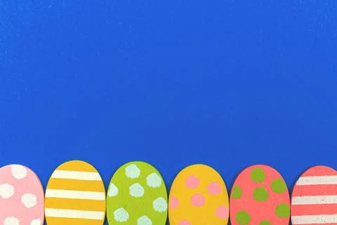 Easter eggs bottom border concept with copy space, flat lay design, holiday c Stock Photos