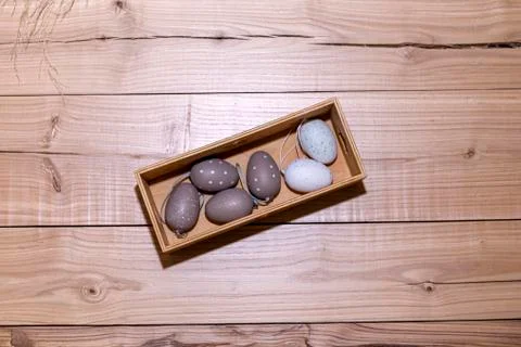 Easter eggs in box on rustic wooden background. Stock Photos