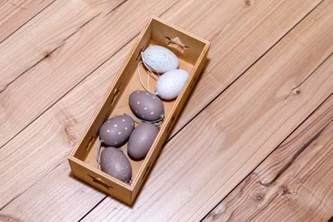 Easter eggs in box on rustic wooden background. Stock Photos