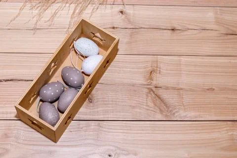 Easter eggs in box on rustic wooden background. Stock Photos