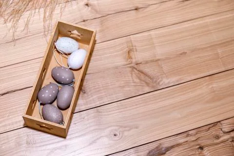 Easter eggs in box on rustic wooden background. Stock Photos