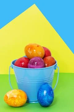 Easter eggs in a bucket on a colored background Stock Photos