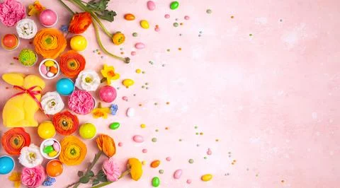 Easter eggs, Bunny, candy and colorful spring flowers on pastel pink backgr.. Stock Photos