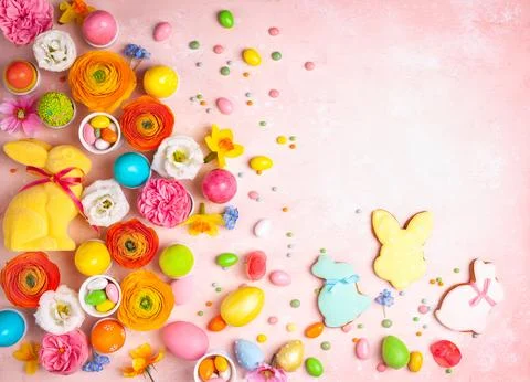 Easter eggs, Bunny, candy and colorful spring flowers on pastel pink backgr.. Stock Photos