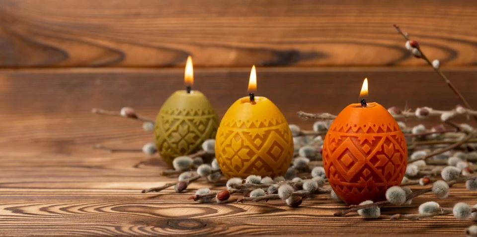 Easter eggs candles on a white texture background Stock Photos