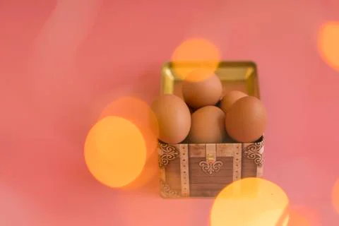 Easter eggs in a chest on a pink background. bokeh Stock Photos