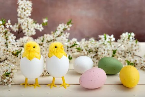 Easter eggs, chicks and spring flowers on wooden background Foto stock