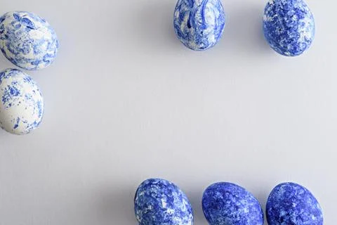 Easter eggs with classic blue gradient effect scattered on white background Stock Photos
