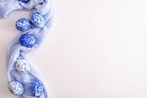 Easter eggs with classic blue gradient effect laid out on soft blue napkin on Stock Photos