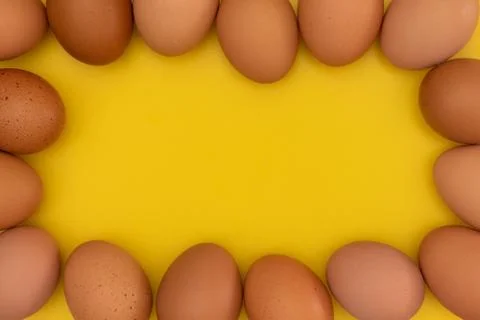 Easter eggs creating a frame on a yellow background 库存照片