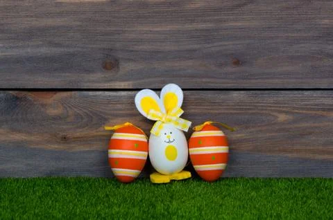Easter eggs cute bunny. Green grass. Wooden background. Happy Easter. Stock Photos