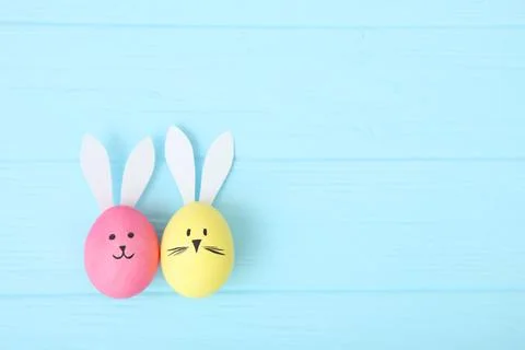 Easter eggs with cute faces and ears on a colored background. Stockfoto's