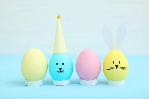 Easter eggs with cute faces and ears on a colored background. Stock Photos