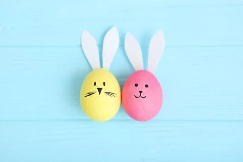 Easter eggs with cute faces and ears on a colored background. Stockfoto's