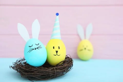 Easter eggs with cute faces and ears on a colored background. Stock-Fotos