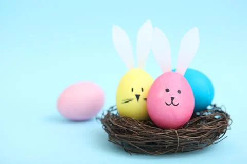 Easter eggs with cute faces and ears on a colored background. Stock-Fotos