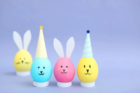 Easter eggs with cute faces and ears on a colored background. Stock-Fotos