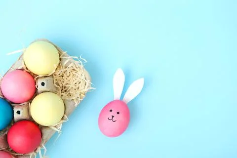 Easter eggs with cute faces and ears on a colored background. Stock-Fotos