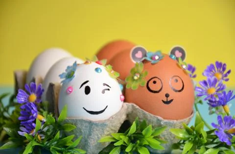 Easter eggs with cute faces close-up on a yellow-blue background. Easter. Stock Photos