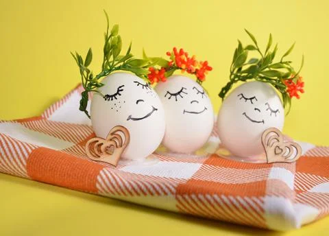 Easter eggs with cute faces on a napkin. Stock Photos