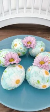 Easter eggs with daisies on a blue background Stock Photos