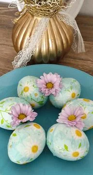 Easter eggs with daisies on a blue background Stock Photos