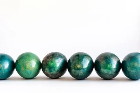 Easter eggs decorated in different shades of turquoise and gold lined on white Stock Photos
