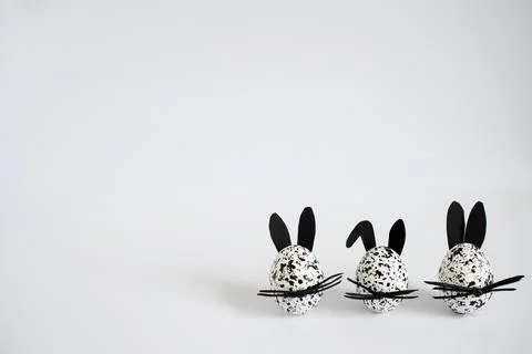 Easter eggs decorated as spotted black and white bunnies on the white background Stock Photos