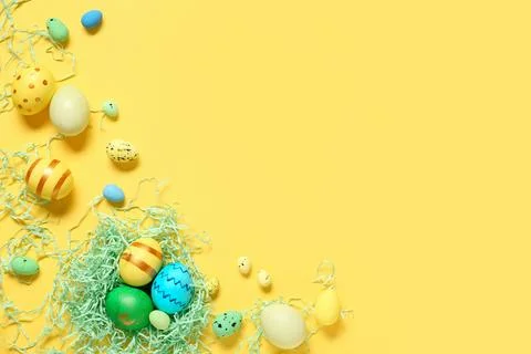 Easter eggs with decorative shredded paper on yellow background Stock Photos