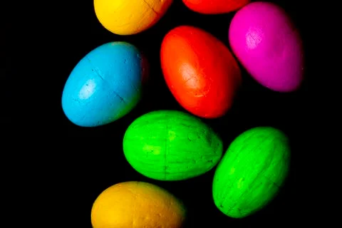 Easter eggs of different colors on a black background. Stock Photos