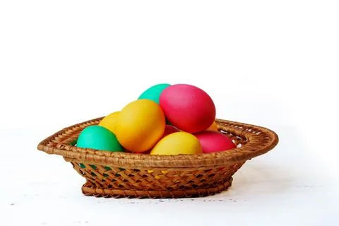Easter eggs of different colors in a wicker basket Stock Photos