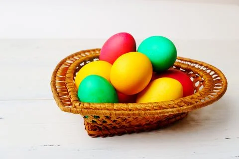 Easter eggs of different colors in a wicker basket Stock Photos