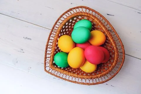 Easter eggs of different colors in a wicker basket Stock Photos