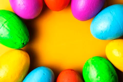 Easter eggs of different colors on a yellow background. Stock Photos